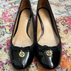 Black patent 1.5” heeled Tory Burch ballet shoes with gold charm.